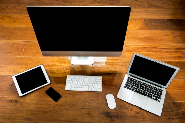 iMac, MacBook and iPad arranged on a desk, viewed from above